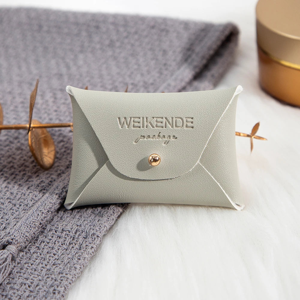 100 Stück Silberne Schmuckbeutel mit Logo – 10x7cm Lederbeutel mit Kordelzug | Für Ohrringe, Ringe, Halsketten, Münzen & Schlüsselanhänger