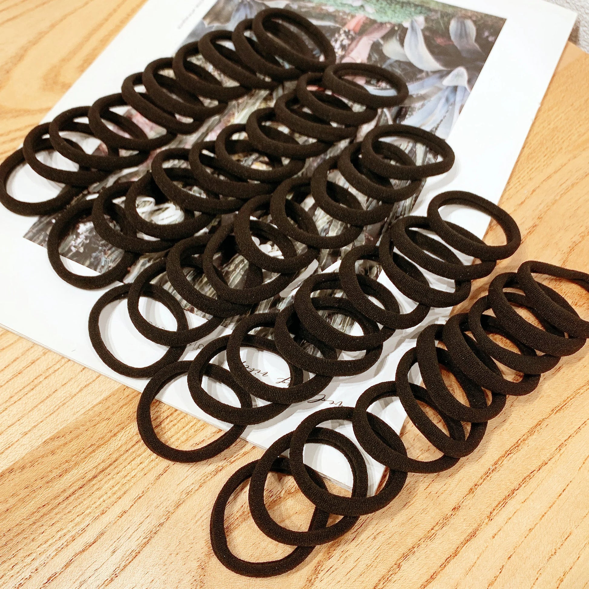 Großpackung mit 50 oder 100 hochwertigen schwarzen Haargummis – geeignet für alle Haartypen und Frisuren. Kaufschwan®